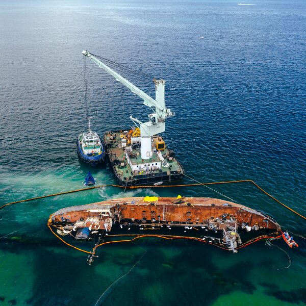 How Oil Containment Boom Protects Marine Ecosystems 1 An oil tanker capsized in the ocean surrounded by an oil containment boom