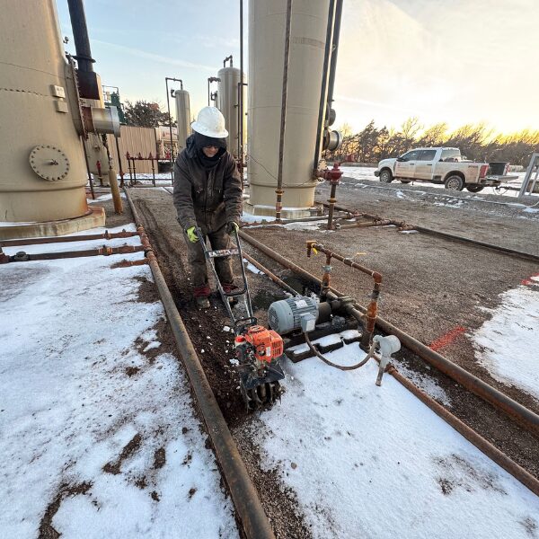 ACME employee hand tilling an area contaminated with oil