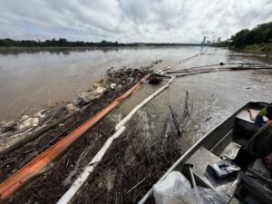Oil containment boom and absorbent boom deployed to prevent further spread of debris and oil