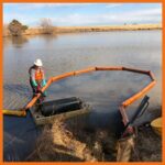 10" creek and swamp boom deployed with an oil drum skimmer to contain and clean up a thick oil spill