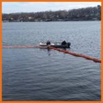 12" fastwater river and creek boom being deployed around a sunked boat that had caught fire