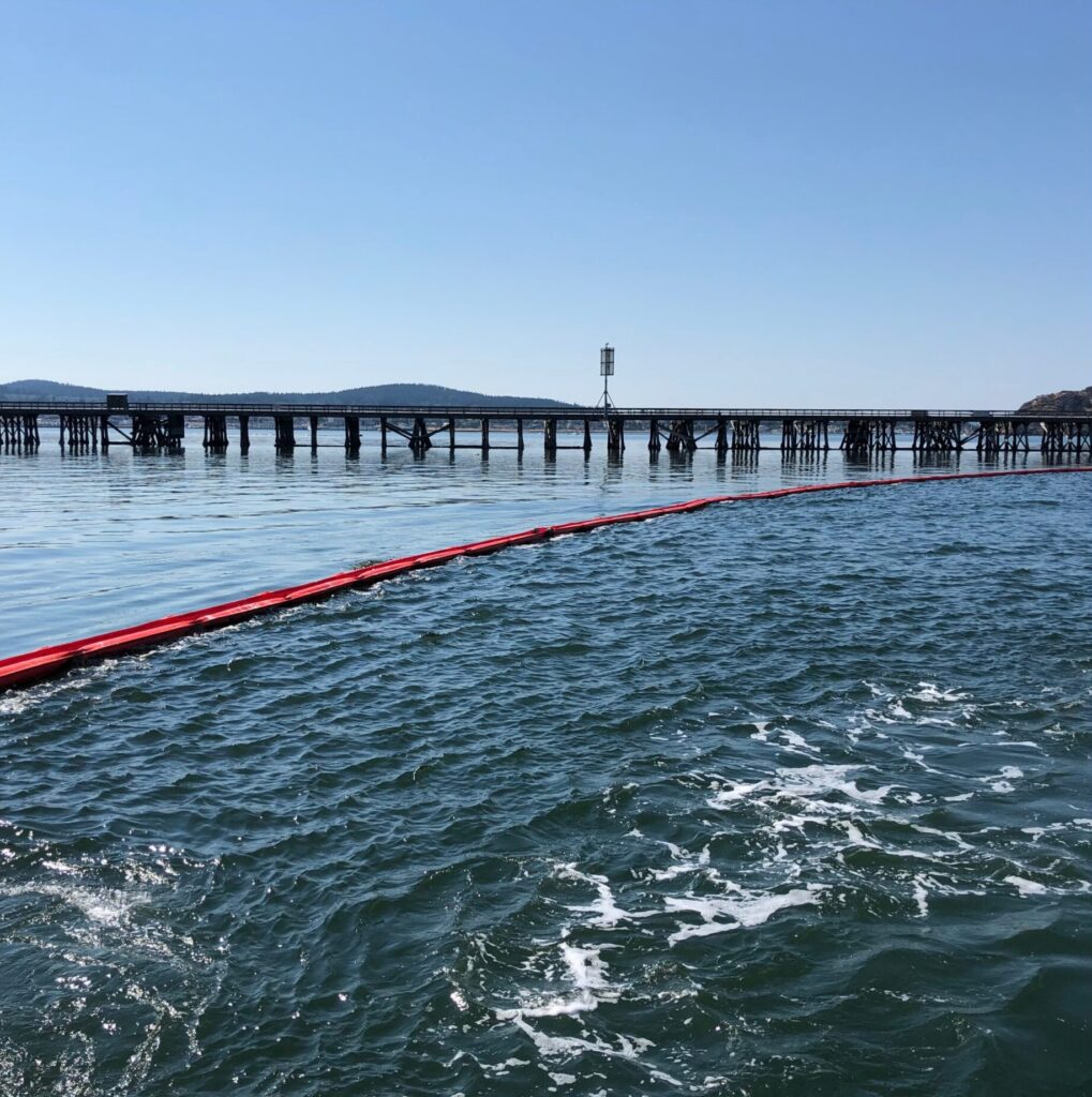 A picture of ACME's 20" offshore containment boom preventively deployed near bridge to keep any spilled oil contained