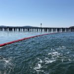 A picture of ACME's 20" offshore containment boom preventively deployed near bridge to keep any spilled oil contained