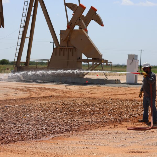 Well Maintenance Through Till-And-Treat 4 ACME worker spraying our proprietary blend on oil-contaminated soil that had been tilled