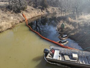 Containment Boom deployed to prevent spread of oil while an Oil Skimmer removes oil off the water surface
