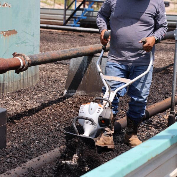Well Maintenance Through Till-And-Treat 5 A picture of a hand-tiller being used to reach tight spaces where oil-contaminated soil is present