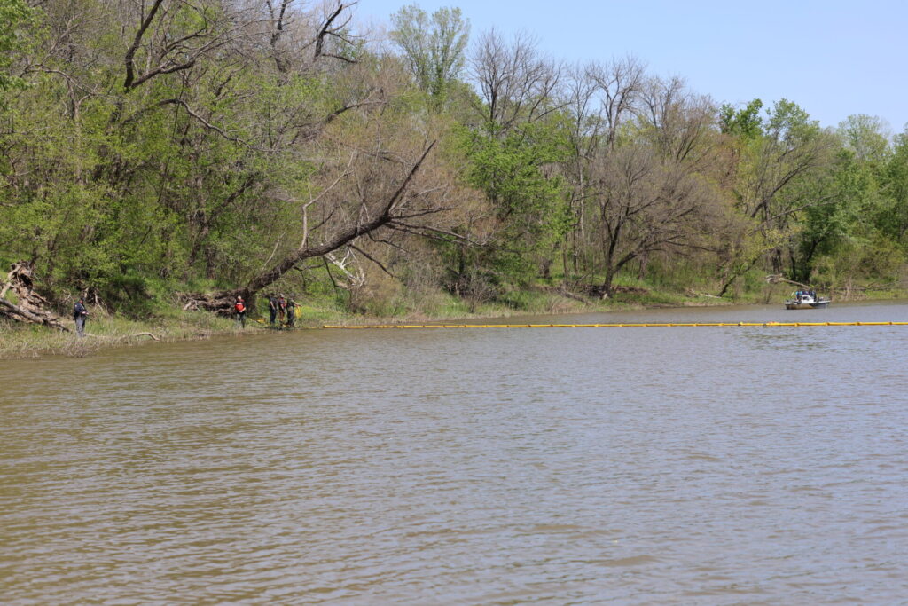 Containment boom being pulled across river
