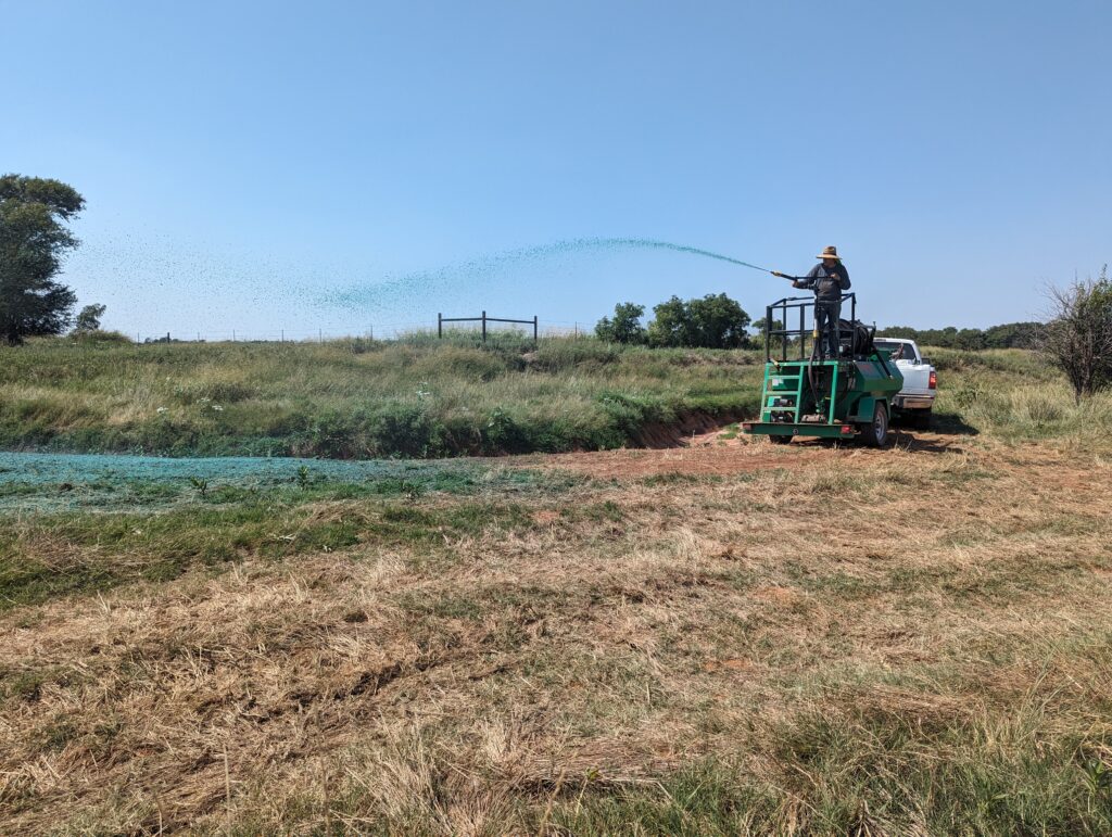 ACME employees hydroseeding soil after it had been remediated