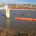 ACME employees anchoring Inflatable Boom