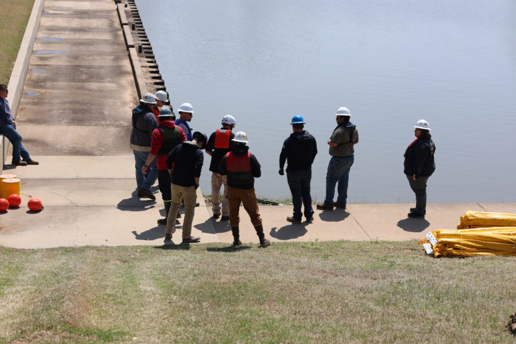 Students preparing for a containment boom deployment drill in a marina