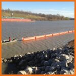 ACME employees pulling inflatable boom to proper deployment location