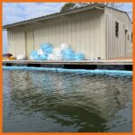 Absorbent boom deployed around a boat dock to contain spilled oil