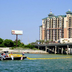 Boat laying out boom on water
